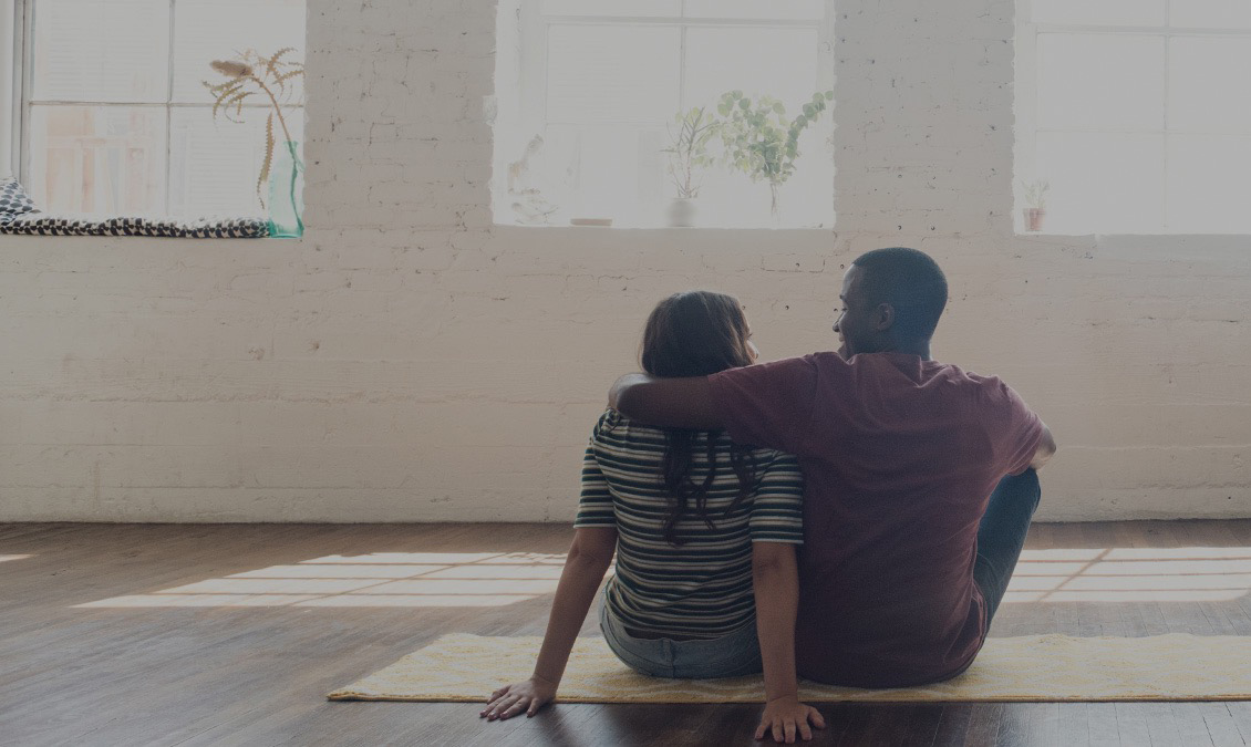 couple sitting on rug in apartment